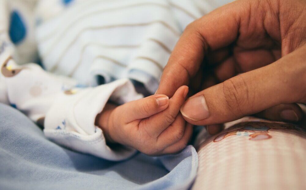 Photo by Aditya Romansa person holding baby's index finger
